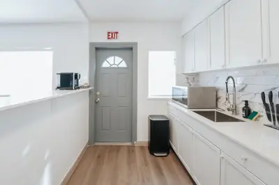 a kitchen with white cabinets and a blue door at PRAIA Hotel Hollywood in Hollywood