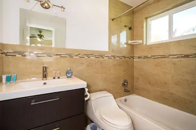 a bathroom with a toilet and a sink and a tub at Tranquil Retreat with HEATED POOL Minutes to the Beach in Dania Beach