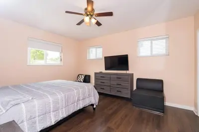 a bedroom with a bed and a ceiling fan at Tranquil Retreat with HEATED POOL Minutes to the Beach in Dania Beach