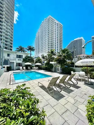 a swimming pool with lounge chairs and buildings at Aqua Hotel in Fort Lauderdale