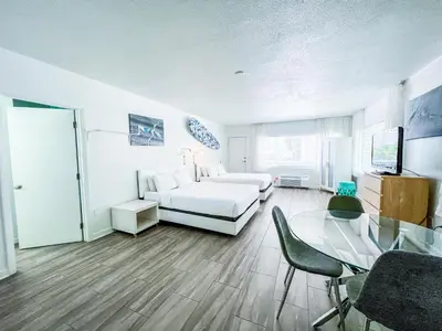 a living room with a white couch and a glass table at Aqua Hotel in Fort Lauderdale