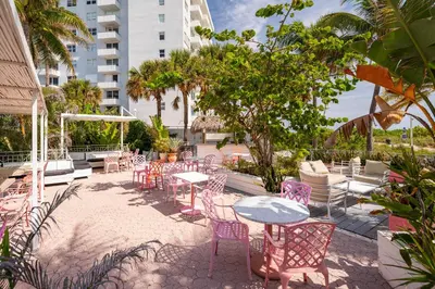 a patio with tables and chairs and a building at The Savoy Hotel & Beach Club in Miami Beach