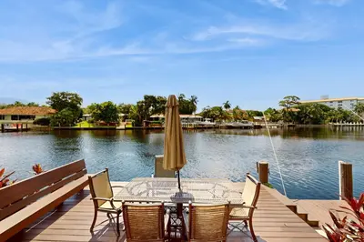 a table with chairs and an umbrella on a dock at Middle River Lookout in Fort Lauderdale