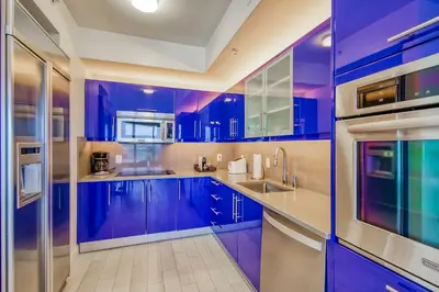 a blue kitchen with white counters and blue cabinets at The Residency at Fort Lauderdale in Fort Lauderdale