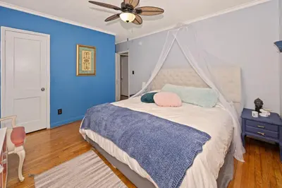 a bedroom with blue walls and a bed with a canopy at Cozy Cottage Near Beach in Hollywood