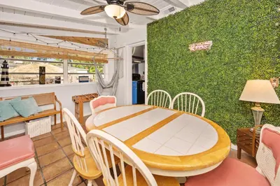 a dining room with a table and chairs and a green wall at Cozy Cottage Near Beach in Hollywood