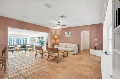 a living room with a couch and a table and chairs at NEWLY RENOVATED POOL, HOT TUB, & EPIC BACKYARD in Fort Lauderdale