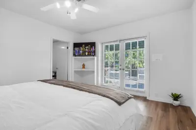 a white bedroom with a large bed and a window at NEWLY RENOVATED POOL, HOT TUB, & EPIC BACKYARD in Fort Lauderdale