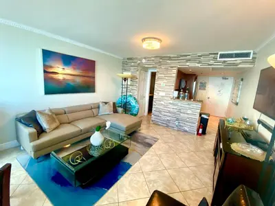 a living room with a couch and a table at Large luxurious direct ocean front Penthouse or Deluxe 1 BR ocean front condo-Beach access- Free parking- Remodeled in Miami Beach