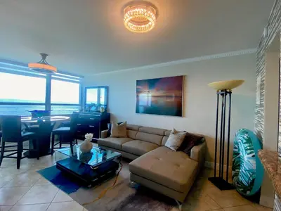 a living room with a couch and a table at Large luxurious direct ocean front Penthouse or Deluxe 1 BR ocean front condo-Beach access- Free parking- Remodeled in Miami Beach