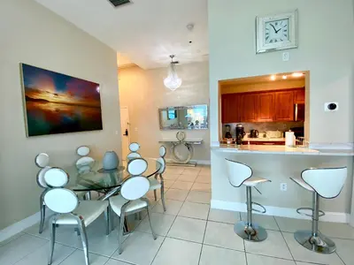 a kitchen with chairs and a table and a counter at Large luxurious direct ocean front Penthouse or Deluxe 1 BR ocean front condo-Beach access- Free parking- Remodeled in Miami Beach