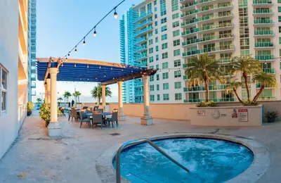 a hot tub on a patio in front of a building at Studios in Brickell with Pool, Gym, free parking and Game Room in Miami