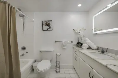 a white bathroom with a toilet and a sink at Studios in Brickell with Pool, Gym, free parking and Game Room in Miami