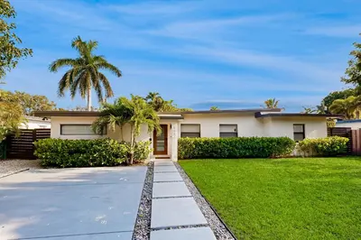 a house with a palm tree and a driveway at Mid-Century Modern Oasis in Miami