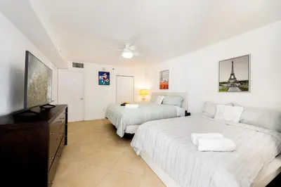 a white bedroom with two beds and a television at Luxury 1BD Apt in Downtown Brickell free parking in Miami