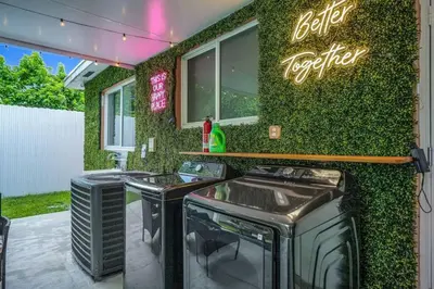 a restaurant with two bar stools and a green wall at Escape GameRoom, BAR, BBQ, Spacious,KING Bed, All Luxury mattresses, Near Beach, 6 blocks away from Bars, Nite Clubs, Res, Shops in Miami