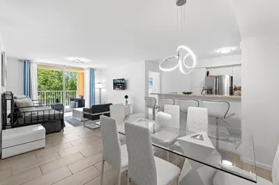 a kitchen and living room with a glass table and chairs at Yacht Club Miami Suite 2 Bedroom and 2 Bathroom With Baby Crib & Free Parking in Miami