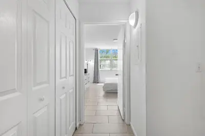 a hallway with white walls and a room with a bed at Yacht Club Miami Suite 2 Bedroom and 2 Bathroom With Baby Crib & Free Parking in Miami
