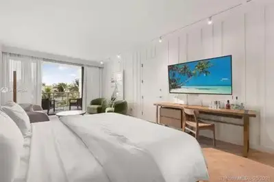 a white bedroom with a large bed and a desk at Residences Suite South Beach in Miami Beach