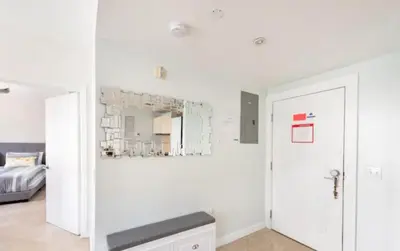 a white room with a bed and a mirror at The Carlyle Oceanfront Luxe Condo Miami Beach in Miami Beach