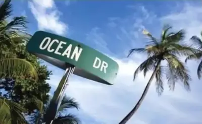 a street sign for ocean drive with a palm tree at The Carlyle Oceanfront Luxe Condo Miami Beach in Miami Beach