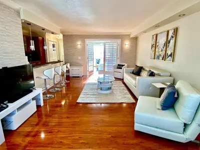 a living room with a couch and a tv and a kitchen at Deluxe waterfront one bedroom apartment with Miami Skyline view, free parking 5 mins drive to Miami Beach in Miami Beach