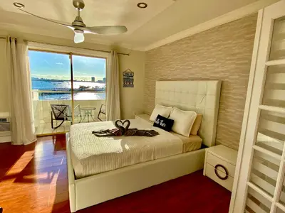 a bedroom with a bed and a large window at Deluxe waterfront one bedroom apartment with Miami Skyline view, free parking 5 mins drive to Miami Beach in Miami Beach