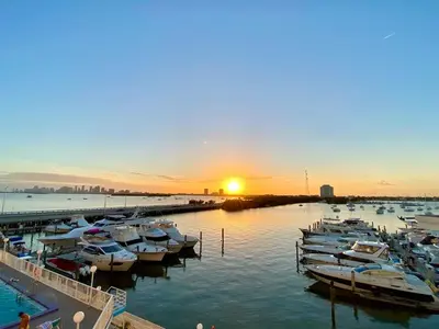 a group of boats docked in a marina at sunset at Deluxe waterfront one bedroom apartment with Miami Skyline view, free parking 5 mins drive to Miami Beach in Miami Beach