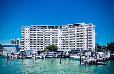 a large building with a marina and boats in the water at Deluxe waterfront one bedroom apartment with Miami Skyline view, free parking 5 mins drive to Miami Beach in Miami Beach