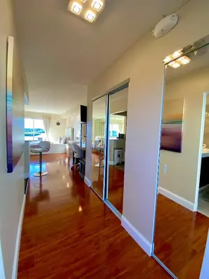 a living room with a hard wood floor and glass walls at Modern waterfront apartment with Miami Skyline view, free parking 5 mins drive to Miami Beach in Miami Beach
