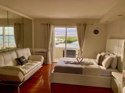 a bedroom with a bed and a couch and a window at Modern waterfront apartment with Miami Skyline view, free parking 5 mins drive to Miami Beach in Miami Beach