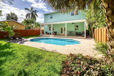 a backyard with a swimming pool and a house at Las Olas Villa with HEATED Salt Water Pool in Fort Lauderdale