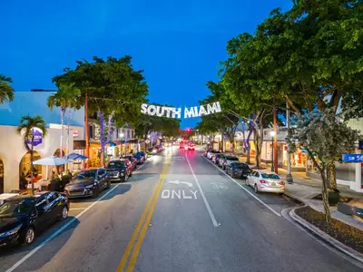 a city street with cars parked on the street at Sunset Inn-South Miami in South Miami