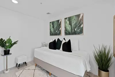 a white bedroom with a bed with black pillows at LUXURY 1 BDRM/1B APT IN MIAMI DESIGN DISTRICT AREA in Miami