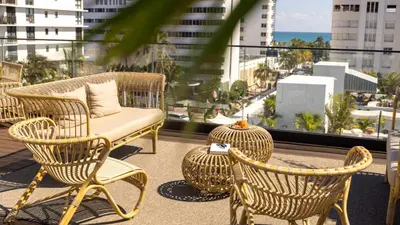 a balcony with wicker chairs and a table and a view at Uma House by Yurbban South Beach in Miami Beach