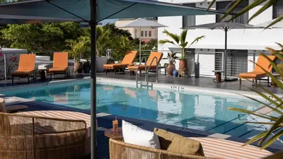 a swimming pool with chairs and umbrellas on a building at Uma House by Yurbban South Beach in Miami Beach
