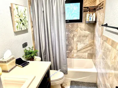 a bathroom with a tub and a toilet and a television at 3 Bed - Sleeps 6 - Free Parking - 5 Mins to Beach in Hollywood