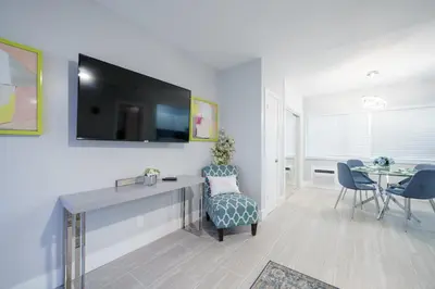 a living room with a tv and a table and chairs at The Surf Hollywood Beach in Hollywood
