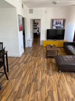 a living room with wooden floors and a flat screen tv at SOBE suites in Miami Beach in Miami Beach