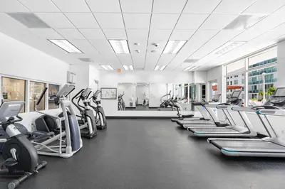 a gym with rows of treadmills and elliptical machines at Luxurious 3BR Condo with Pool in Brickell in Miami