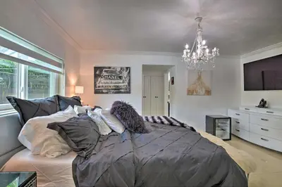 a large bed in a bedroom with a chandelier at Miami Home Outdoor Pool with Slide and Fire Pit! in Kendall