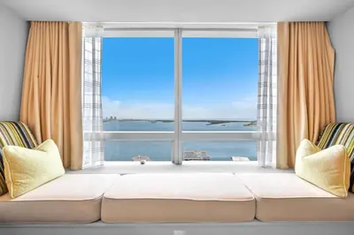 a living room with a large window with a view of the ocean at 2 Bedroom OR King Studio Suites Four Seasons Hotel Miami Free Wi-Fi & Free Parking in Miami