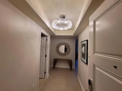 a hallway with a chandelier hanging from a ceiling at 2 Bedroom OR King Studio Suites Four Seasons Hotel Miami Free Wi-Fi & Free Parking in Miami