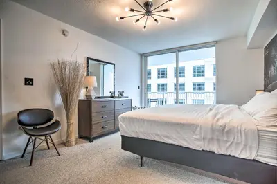 a bedroom with a bed and a chair and a window at Waterfront Condo with View about 6 Miles to South Beach! in Miami