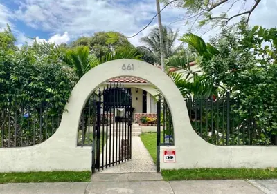 a gate to a house with the number on it at Entire private Beautiful 2 Bedroom plus Den House with gated front&back yard and Free parking 10min drive to Miami Beach in Miami