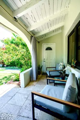 a porch with two couches and an archway at Entire private Beautiful 2 Bedroom plus Den House with gated front&back yard and Free parking 10min drive to Miami Beach in Miami