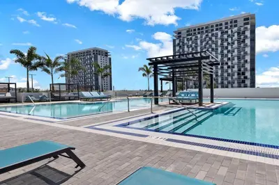 a swimming pool with a picnic table next to a building at Luxury Studio Apartment in Downtown Doral in Miami