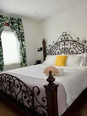 a bedroom with a large bed with a wrought iron headboard at Stunning Little Havana Suites Close to airport, Calle Ocho, Brickell, Wynwood and the Beaches - Free Parking in Miami