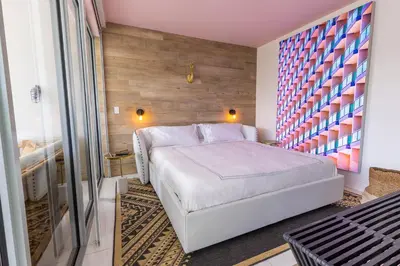 a bedroom with a white bed and a colorful wall at Boutique Suite with Huge Terrace and Rooftop Pool in Miami Beach