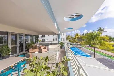 a balcony with tables and chairs and a view of the street at Boutique Suite with Huge Terrace and Rooftop Pool in Miami Beach